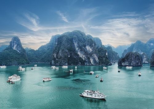 Tourist junks floating among limestone rocks at early morning in Ha Long Bay