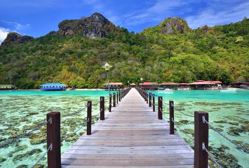 Long wooden pier heading toward Bohey Dulang Island in Sabah Borneo Malaysia.
