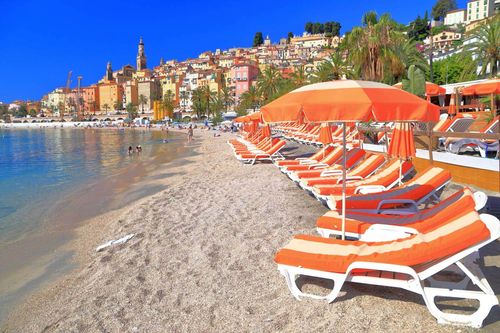 Relaxing beach chairs on sandy sea shore near Menton, French Riviera, France