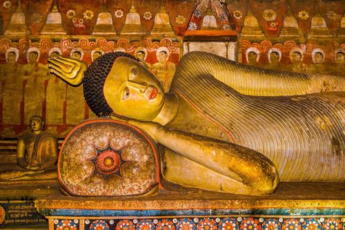 A statue of reclining Buddha in the ancient Buddhist cave temple at Dambulla, Sri Lanka.